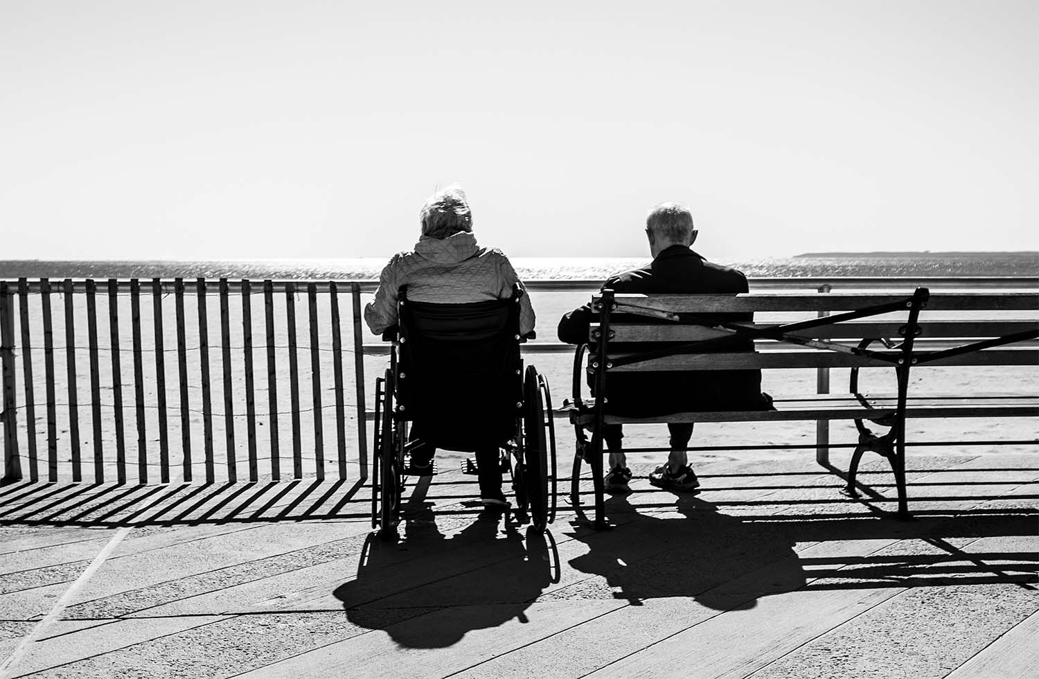 Residents sitting on a bench overlooking the coast