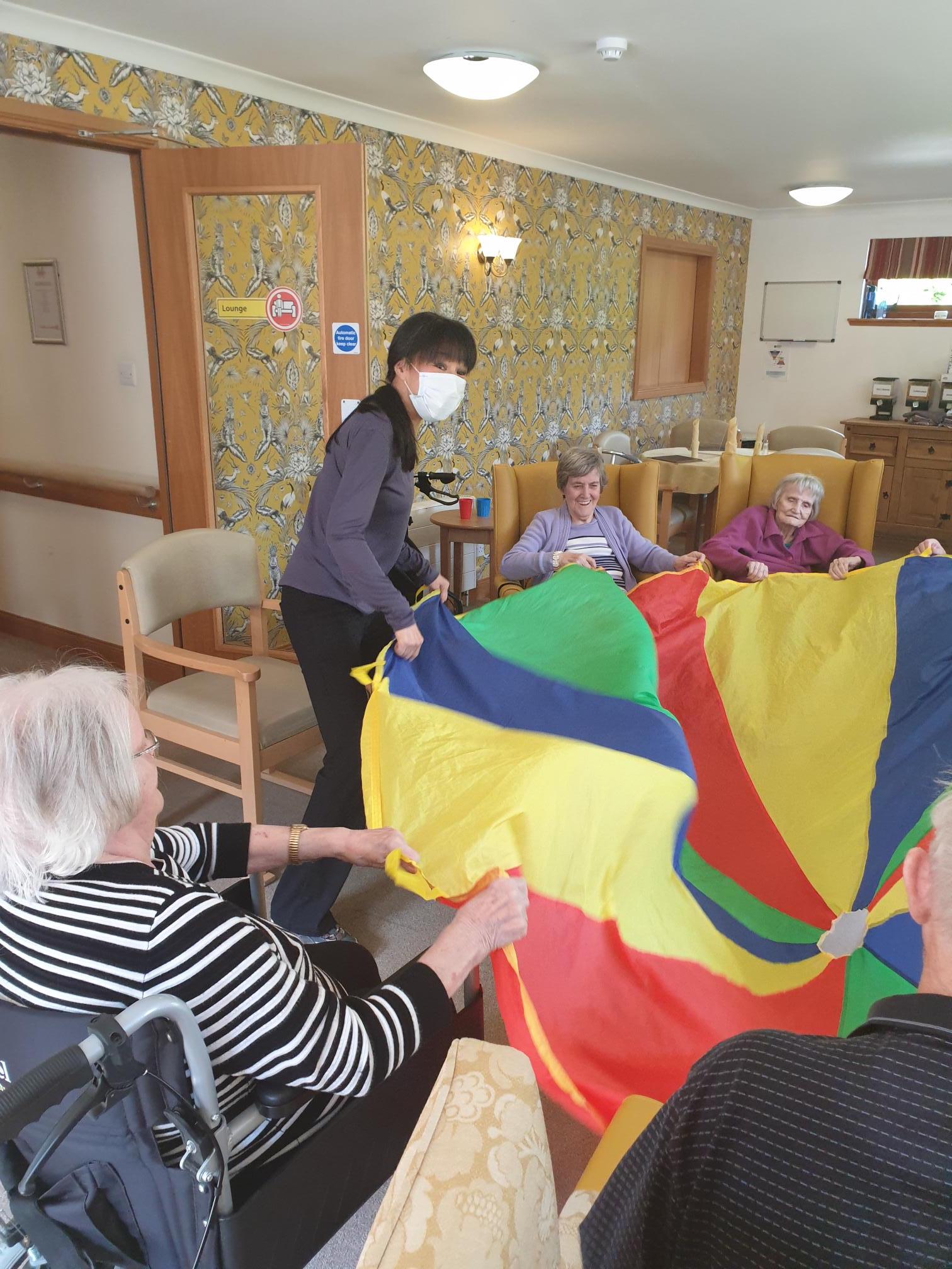 Residents & Staff Playing with Parachute
