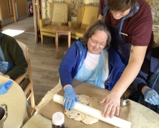 Care home resident rolling out dough