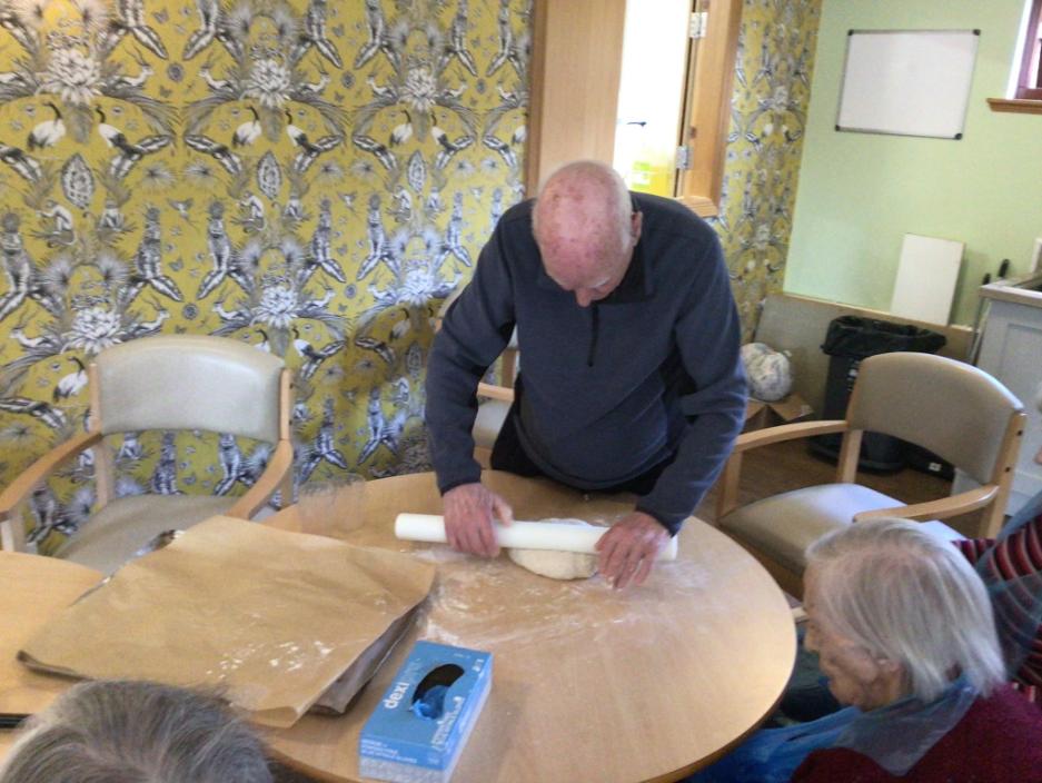older man rolling dough for baking