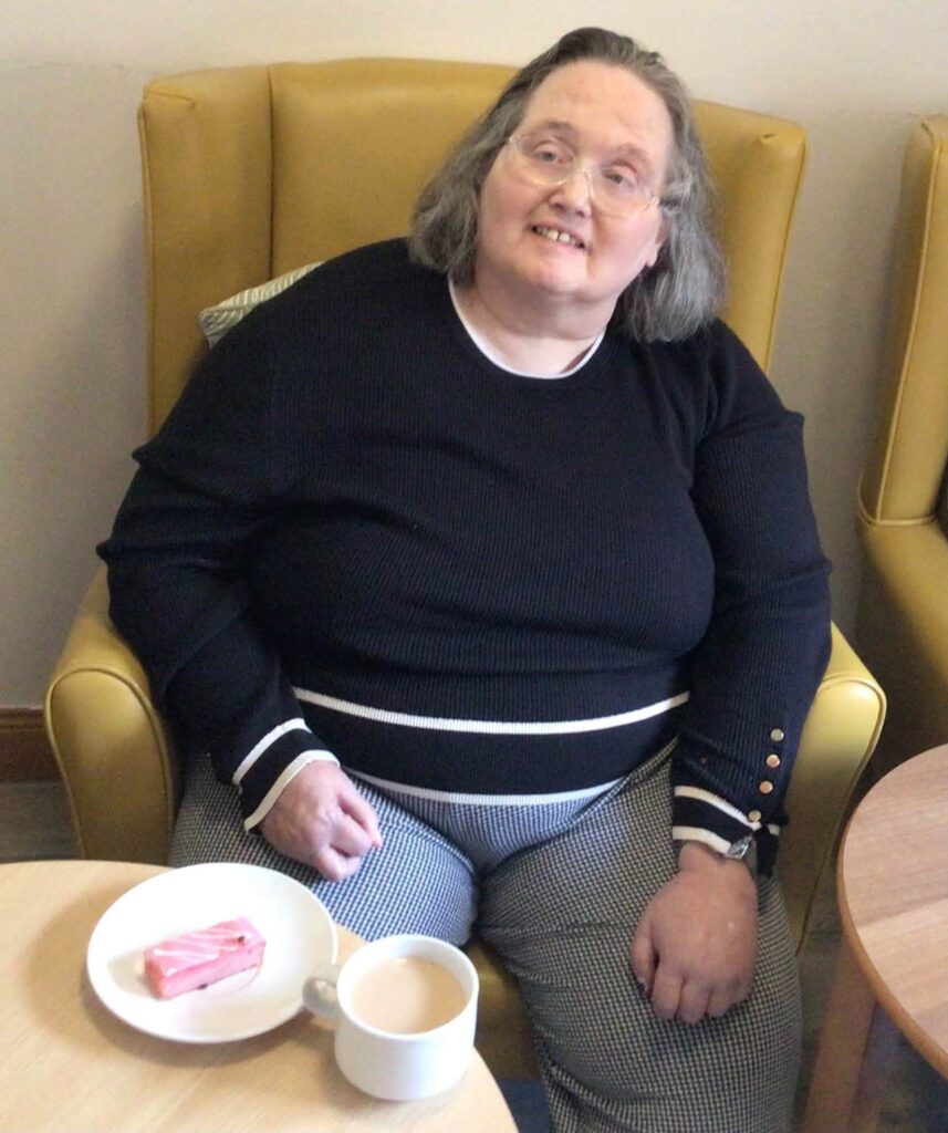 elderly woman smiling with cake
